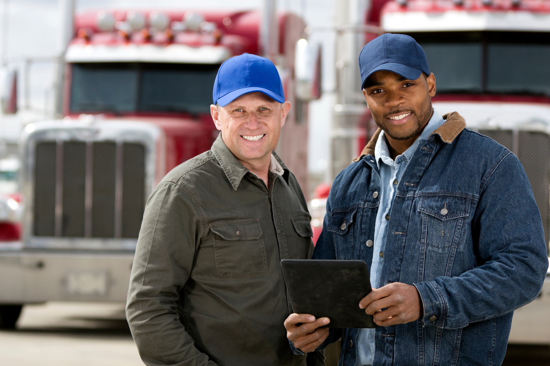 two truck drivers in front of semis